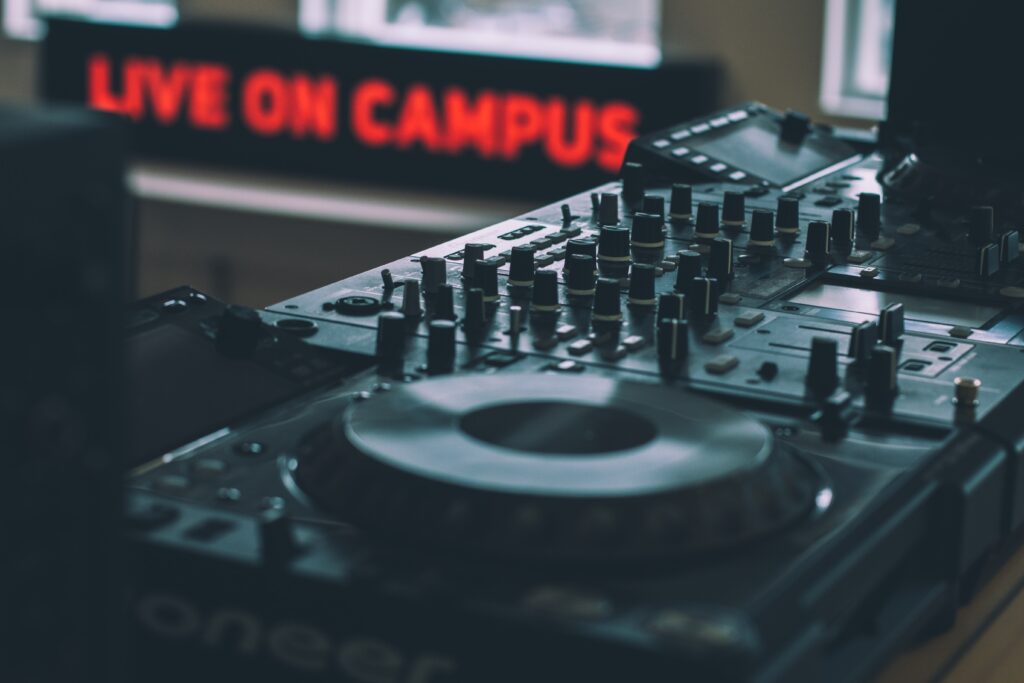 Live on Campus red neon sign, turn tables, dj equipment, mess up in community college